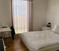 white walls, wooden floor, bed, desk, lamps, nightstand, window with blinds