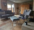 Fireplace, couch, chair, fireplace, rug, table, remote control, cups, vase