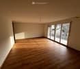 empty room with wooden floors, white walls, sliding glass doors to balcony