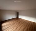 empty room, wooden floor, white walls, door, power outlets