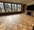 open space with large windows, fireplace, hardwood floors, chandelier, empty