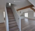 room, wooden floor, staircase, white walls, ceiling lamp, ceiling beams, kitchen