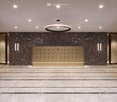 Modern hallway with marble walls, polished marble floor, recessed ceiling lights, and a central circular pendant light above a gold-colored console with mail slots.