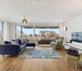 large windows, balcony, rug, sofa, flatscreen tv, shelf, armchairs