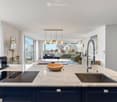 open kitchen with wooden bowl, induction stove, sink, modern faucet, marble counter, blue cabinets, large windows, balcony with railing, table, round lamp