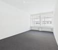 empty room, white walls, gray carpet, large window, radiators