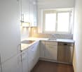 modern kitchen with granite countertop, dishwasher, washing machine, window, bright