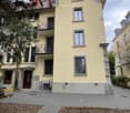 3 story yellow house, several windows, balcony, 2 doors