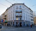5 story corner house, white exterior, balcony, large sign saying 'Weisse Kreuz'