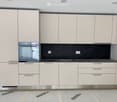 modern kitchen with white cabinets, black marble countertop, stainless steel sink, built-in oven, power outlets