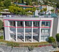 3 story house with balconies and terraces, large windows, surrounded by plants, with a distant mountain view
