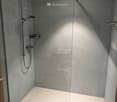 shower area with glass enclosure, shower head, shower arm, shower tray, drain