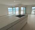 modern kitchen with marble countertop, black induction hob, white cabinets, sliding glass doors, balcony, panoramic view