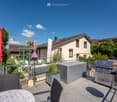 House with a balcony, outdoor grill, storage box, and a view of the surrounding area