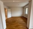 empty room, wooden floor, white walls, white doors, window with white frame, power outlet, radiator