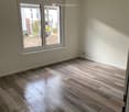 empty room, wooden floor, white walls, large window, power outlets
