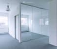 empty room, glass wall, white walls, gray floor, two windows, two radiators, two lamps