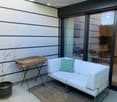 white couch, small table, wicker basket, potted plant, sliding glass door, rug