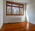 empty room, wooden floor, white walls, large window, radiator
