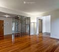empty room, wooden floor, white walls, spiral staircase, floor lamp, power outlets