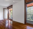 empty room, wooden floor, white walls, large glass doors, balcony