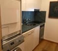 A small kitchen with a washing machine, dishwasher, sink, and stove.