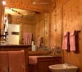 Bathroom with wooden walls, bathtub, sink, bidet, and toilet