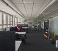 modern office space with glass walls, desks, chairs, plants, and office equipment