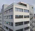 modern office building, white exterior, large windows, balcony on top floor