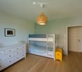 white bunk bed, white dresser, yellow storage box, picture frame, wicker basket, lamp
