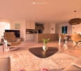 open plan living room with kitchen, beige furniture, wooden floor, large windows, dining table, TV, artwork