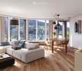 large windows, modern furniture, wooden floor, large sofa, dining table, view of the mountains