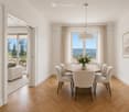 Modern dining room with wooden floor, round table, white chairs, and a view of the outdoors.