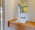 Bathroom. Modern bathroom with a white sink on a wooden vanity, a large mirror above, and a window providing natural light.