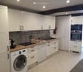 Kitchen. Modern kitchen with white cabinets, wooden countertops, stainless steel appliances, and a decorative backsplash.