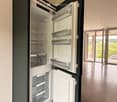 Kitchen. Modern kitchen with a built-in refrigerator, sleek design, and large sliding glass doors leading to a balcony.