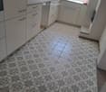 Kitchen. Modern kitchen with white cabinets, a sink, and a floral-patterned tile floor.