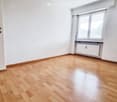 Unfurnished Room. Empty room with wooden flooring, white walls, a window with blinds, and a radiator below the window.
