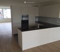 modern kitchen, white cabinets, black countertop, oven, dishwasher, sink, faucet