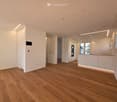 Unfurnished Room. Empty room with light wooden flooring, white walls, and built-in white cabinets. The space features recessed lighting and a large white door.