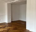 Unfurnished Room. Empty room with wooden herringbone flooring, white walls, and recessed lighting. No furniture or equipment present.