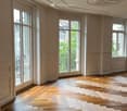 Unfurnished Room. Empty room with wooden herringbone flooring, large windows, and decorative ceiling moldings.
