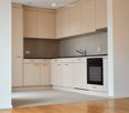 Kitchen. Modern kitchen with light-colored cabinets, a built-in oven, and a sleek faucet. The floor is made of light wood, and the walls are painted in a neutral tone.