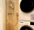 Bathroom. Modern bathroom with a glass-enclosed shower and a stacked washer-dryer unit.