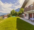House with balcony, garden with table and chairs, mountain view