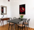 Furnished Room. Dining area with a black dining table surrounded by four chairs, a small wooden side table with a candle and glasses, a decorative mirror, and a vintage-style poster on the wall.