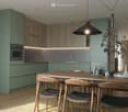 Modern kitchen with light green cabinets, wooden dining table, four chairs, pendant light, and decorative items on the table.