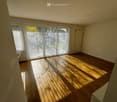 empty room, wooden floor, sliding glass doors, white walls, sunlight