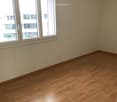 Empty room with wooden flooring and large windows, no furniture or equipment present.