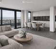 Modern open-plan living and dining area with large windows offering a city view, a grey sectional sofa, a wooden coffee table, a dining table with six chairs, and a sleek kitchen with white cabinets and stainless steel appliances.